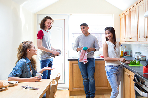 Four students gather and work in the kitchen